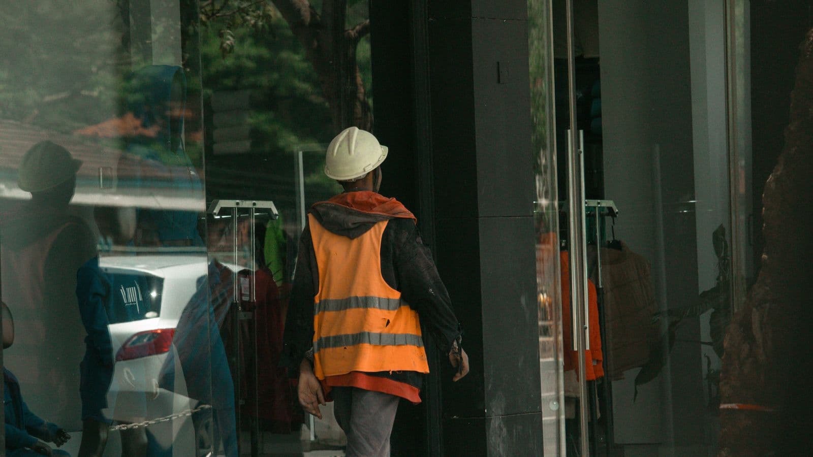 Construction worker in safety vest and hard hat reviewing an incident report on a tablet