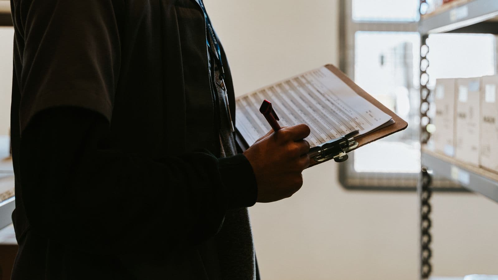 Safety supervisor checking OSHA recordable criteria against a workplace injury report on a clipboard