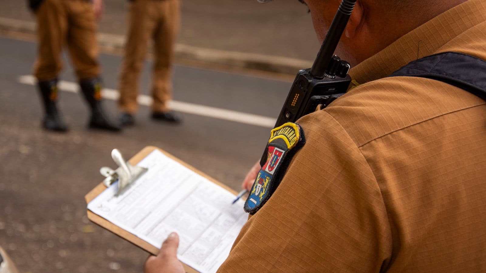 A safety manager reviewing an incident report on a clipboard in a workplace